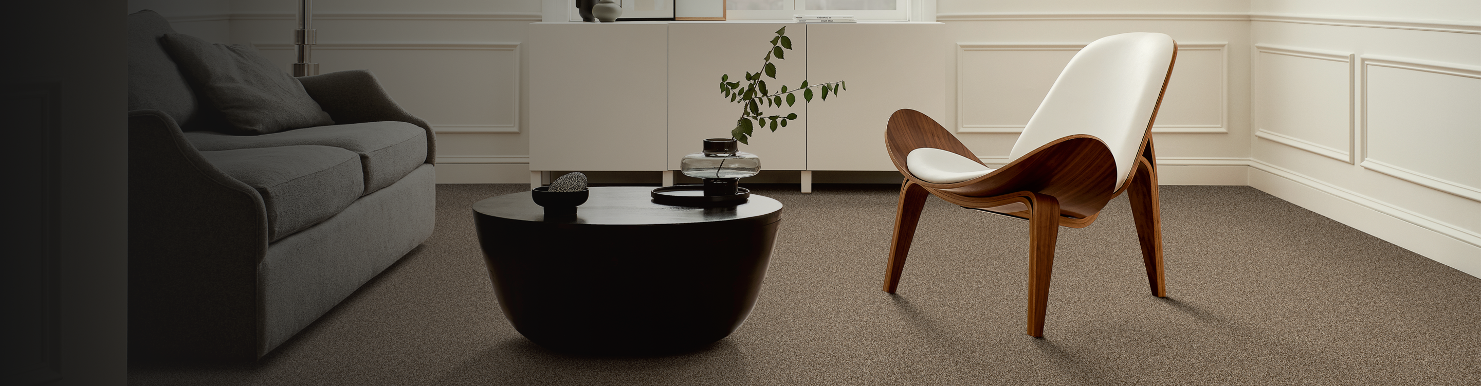 Living room with brown couch and two chairs, beige carpet